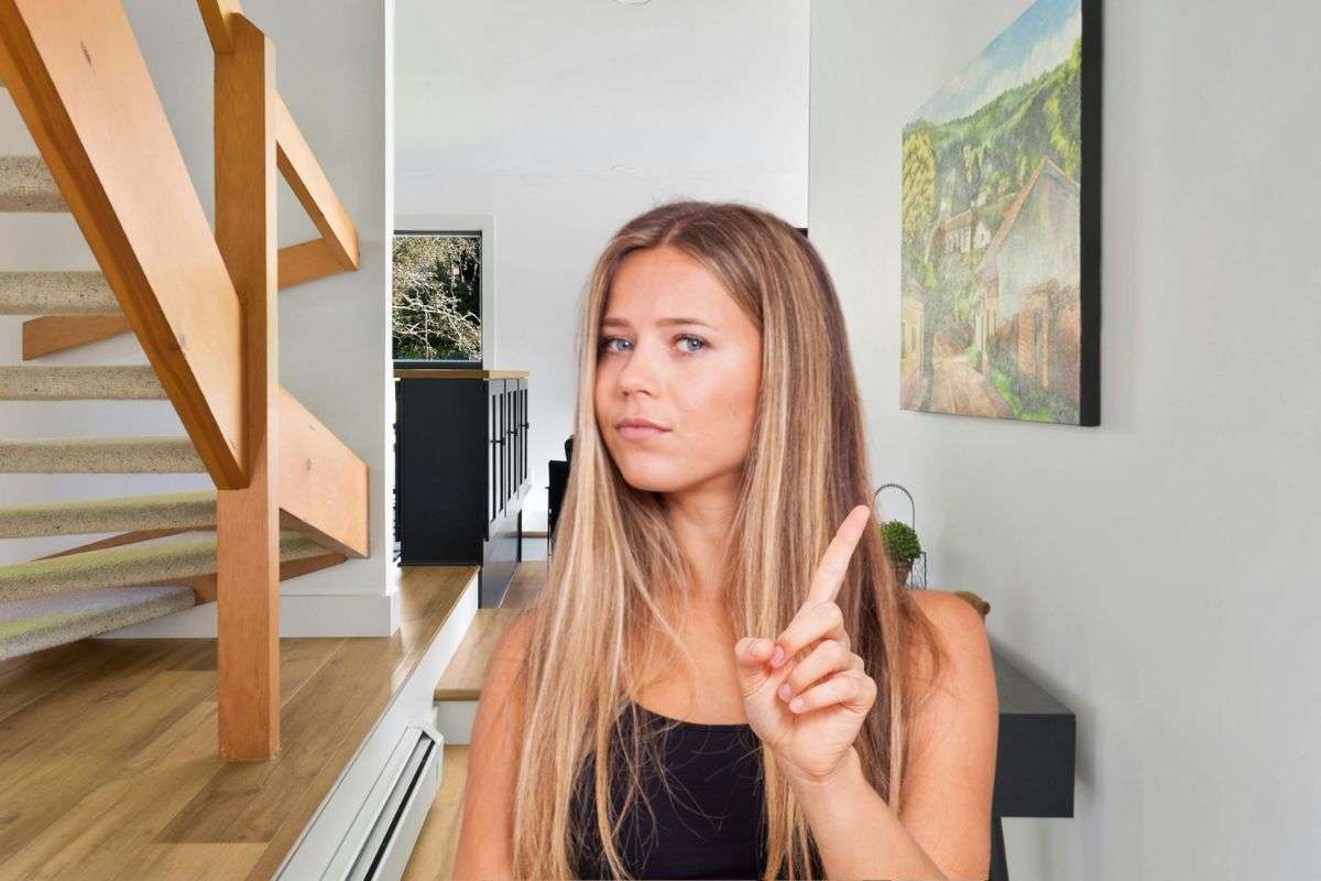 donna che dice no e alle sue spalle un corridoio con un quadro