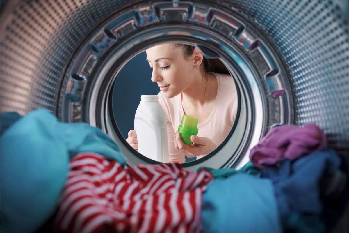donna che odora detersivo per lavatrice