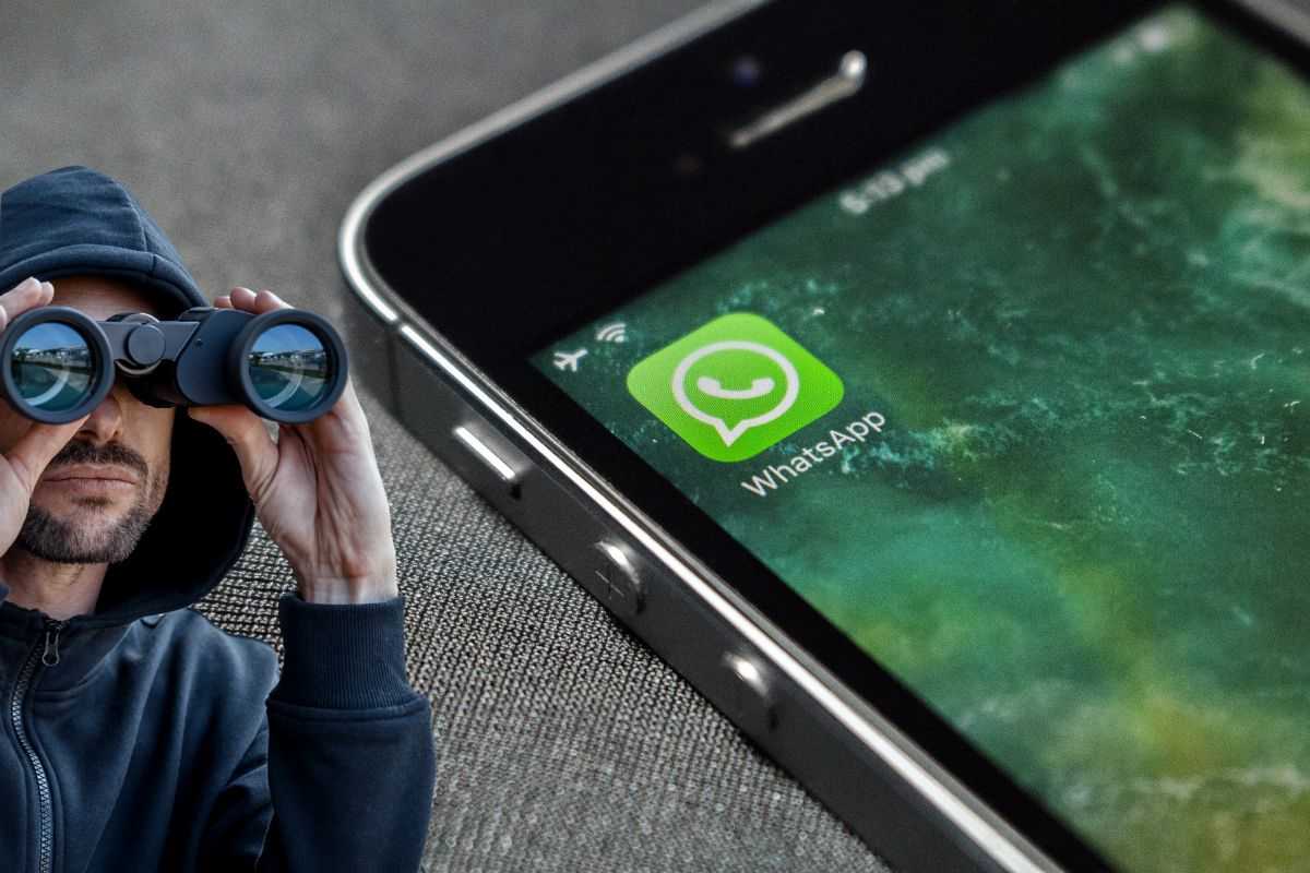 smartphone con logo di whatsapp e persona che spia